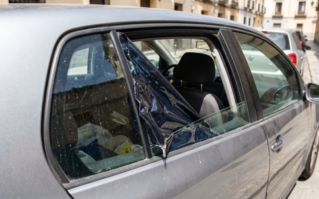 Lámina solar de coche despegada y burbujeada en la ventanilla trasera de un vehículo gris. Detalle de film solar de mala calidad deteriorado por el sol, capturado con nitidez profesional