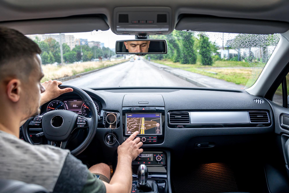 Hombre tocando la pantalla de un sistema de navegación gps en su coche